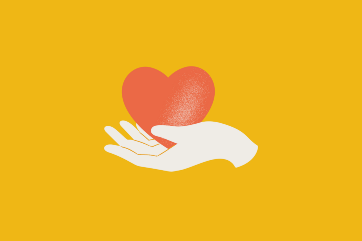 A compassionate hand holding a heart on a vibrant yellow background.