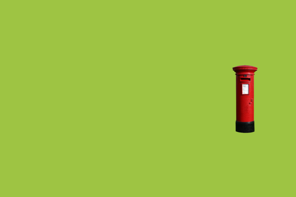 Keywords: post box, green background. 

Modified Description: A post box contrasts against a green background.