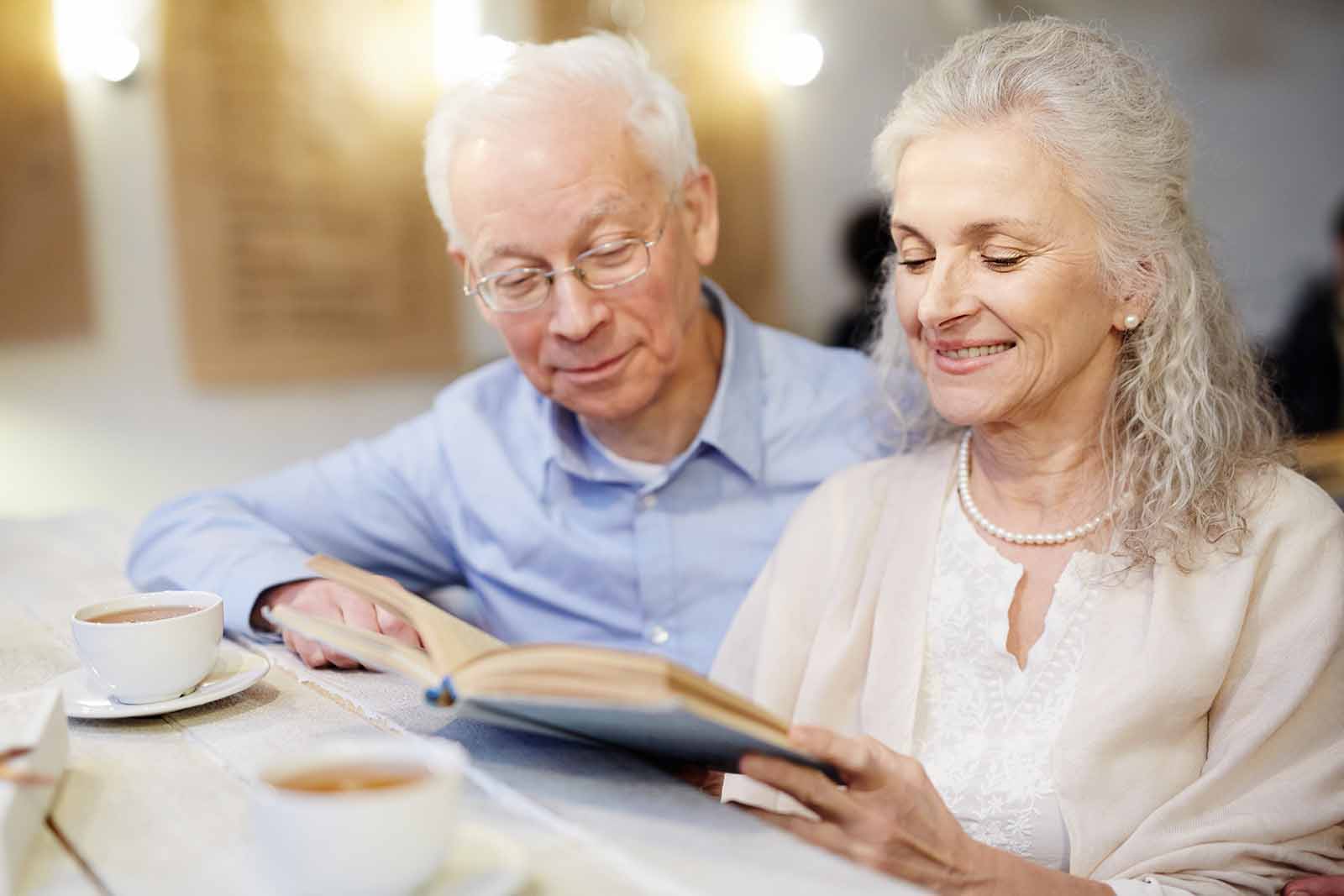 An older couple reading a Gallagher book in a cafe.