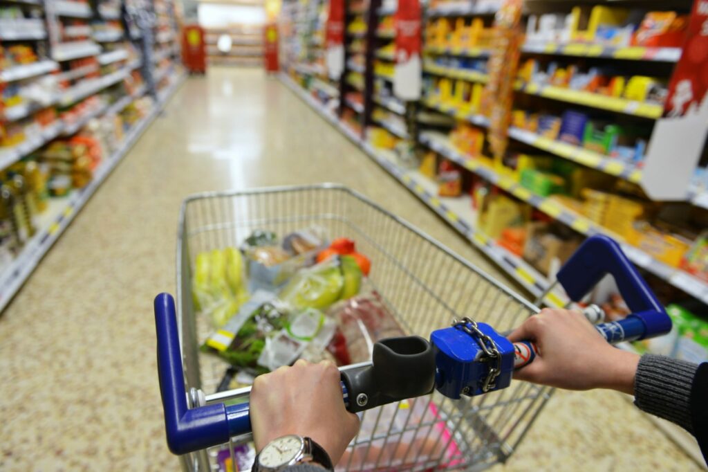 A person is pushing a shopping cart in Tesco.